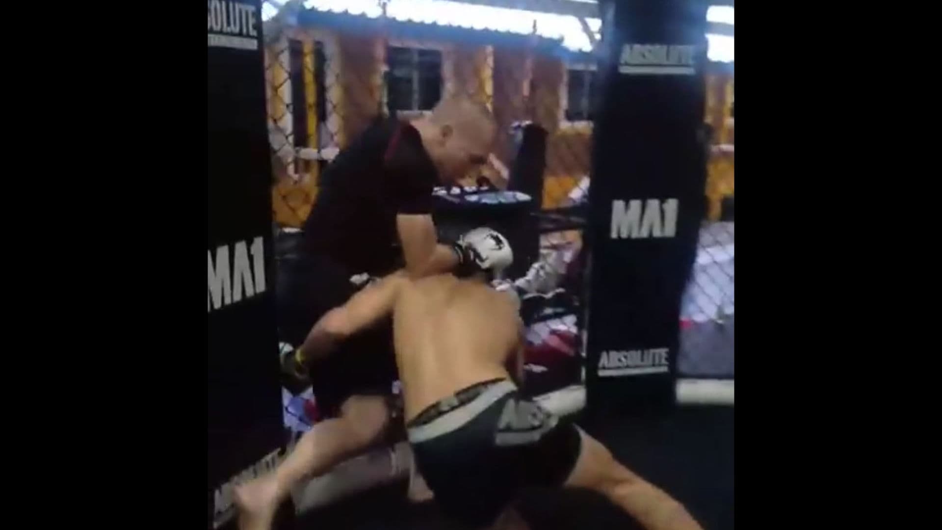 A photo of people training combat sports in an MMA cage